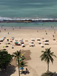 a group of people on a beach with umbrellas at Extraordinary Seafront Apartment in Recife