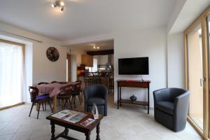 a living room with a table and chairs and a television at Les 3 epines in Rennes