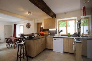 a kitchen with wooden cabinets and a table with chairs at Les 3 epines in Rennes