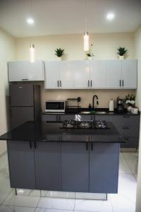 een keuken met witte kasten en een zwart aanrechtblad bij Casa Fénix in Comala