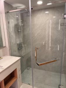 a shower with a glass door in a bathroom at Aston Hotel Pattaya in Pattaya