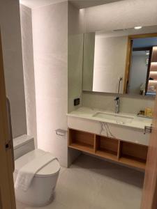 a bathroom with a sink and a toilet and a mirror at Aston Hotel Pattaya in Pattaya