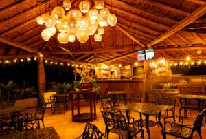 a dining room with tables and chairs and a chandelier at Condado de Casa Grande in San Gil