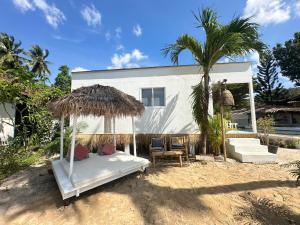 un lit avec un parasol en paille devant une maison dans l'établissement Sama Beach Resort by Munchies Resort, à Baan Tai
