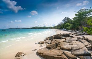 a beach with rocks and people swimming in the ocean at Sea Sand Sun Condominium in Ban Bang Nok +10 photos