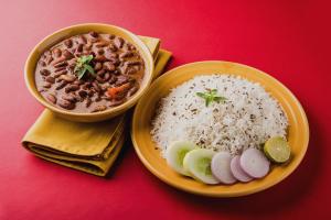 a plate of food with rice and a bowl of soup at Hotel O Ring Road Nagpur Formerly Glory Inn in Khāpri