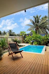 einen Stuhl auf einer Terrasse neben einem Pool in der Unterkunft The Green House in Matavera