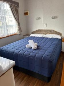 ein blaues Bett mit zwei Handtüchern darauf in der Unterkunft South Goulburn Caravan Park in Goulburn