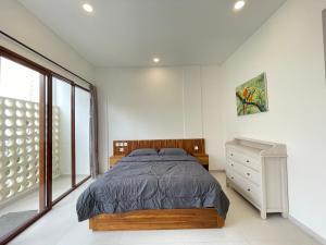 een slaapkamer met een bed, een ladekast en een raam bij Saltera Kedungu in Tanah Lot