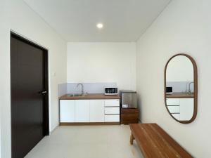 een badkamer met een wastafel, een spiegel en een deur bij Saltera Kedungu in Tanah Lot
