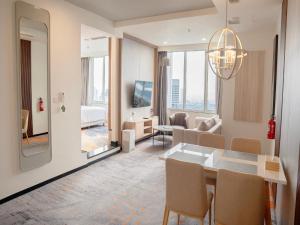 een eetkamer en een woonkamer met een eettafel en een woonkamer bij HARRIS Suites fx Sudirman in Jakarta