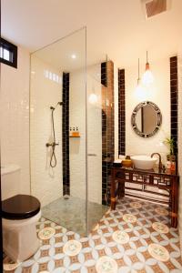 a bathroom with a shower and a toilet and a sink at Baan Chart in Bangkok