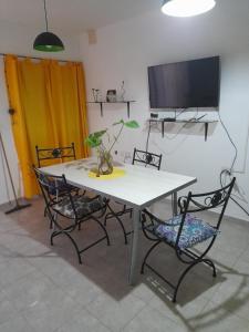 een eettafel met stoelen en een tv bij Casa en la Punta San luis in La Punta