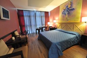 a bedroom with a bed and a living room at Hotel Antares Sport Beauty & Wellness in Villafranca di Verona