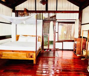 ein Schlafzimmer mit einem Himmelbett in der Unterkunft Bamboo Cottages in Phu Quoc