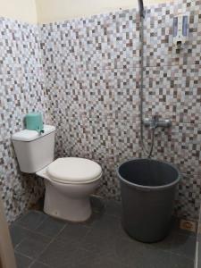 een badkamer met toilet en ligbad bij Hansel Homestay in Batu