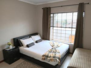 a bedroom with a bed with a large window at Nested at L&MX in Centurion