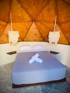a bed with a bow tie on it in a room at Frequency Beachfront Domes El Cuyo in El Cuyo