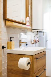 une salle de bain avec un lavabo et un rouleau de papier toilette dans l'établissement Murányi Vendégház, à Mórahalom