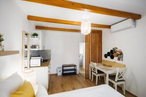 a living room with a kitchen and a table and a room at Murányi Vendégház in Mórahalom