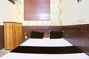 een slaapkamer met een groot bed met een houten wand bij Hotel O cozy suits in Kharar +36 foto's