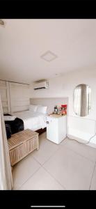 a white bedroom with a bed and a window at Atacama container in Brasília