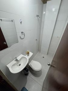 een witte badkamer met een toilet en een wastafel bij Apartamento en Riohacha in Ríohacha +19 foto's