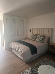 una camera da letto con un letto con due cuscini sopra di Two Tides a Ballito