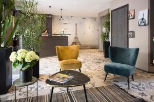 Un vestíbulo con dos sillas y una mesa de café. en Hotel Espace Champerret, en Levallois-Perret