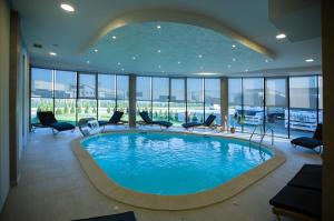 a large swimming pool in a hotel room with chairs at Hotel Exclusive President in Morančani