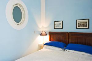 
a bedroom with a white bed and a blue wall at Casa Astarita in Sorrento
