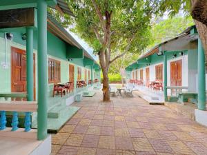 een gebouw met een boom in het midden van een stoep bij Anh Linh Guest House in Mũi Né