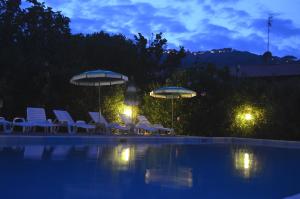 a group of chairs and umbrellas next to a swimming pool at Pozzo al Moro Village in Marina di Campo