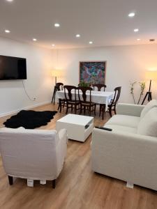 a living room with white couches and a dining room at Deep Cove holiday in North Vancouver