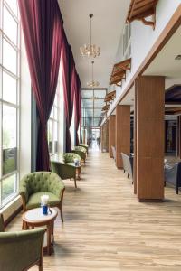 a long corridor with chairs and tables and windows at Le Erawan Phang Nga Hotel in Phangnga