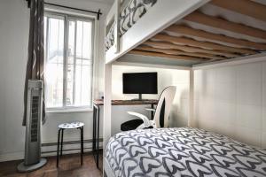 a bedroom with a bed and a desk with a tv at FREE PARKING - In-Suite WASHER & DRYER - fully stocked KITCHEN - WORKSPACE PROVIDED - FAST WIFI - 5 minute walk to the most CENTRAL metro station IN MONTREAL - BERRI UQAM in Montréal