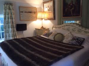 a bedroom with a large bed and a lamp at Bridge Cottage in Midhurst +7 photos