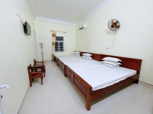 a bedroom with two beds and a chair in it at Hotel Thi Hoa Bai Dinh in Ninh Binh