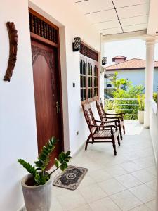 een veranda met 2 stoelen en een deur bij Bay Street in Beruwala