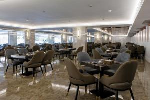 a restaurant with tables and chairs in a room at Maritztel Bangkok Hotel in Ban Bang Toei (1)