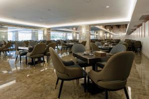 a restaurant with tables and chairs in a room at Maritztel Bangkok Hotel in Ban Bang Toei (1)