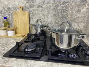 a stove with two pots on top of it at Suite Matrimonial 3plz con cocina y garage in Baños