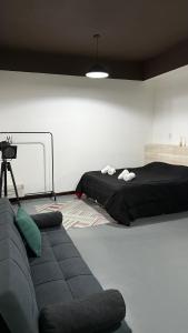 ein Schlafzimmer mit einem Bett und einer Couch in der Unterkunft EzeApart in Ezeiza