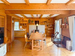 a kitchen and dining room with a wooden table and chairs at yado suzuka in Suzuka