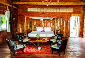 ein Schlafzimmer mit einem Bett, einem Tisch und Stühlen in der Unterkunft Bamboo Cottages in Phu Quoc