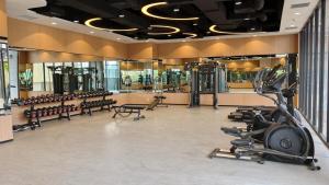 a gym with rows of treadmills and exercise equipment at Saffron Noble Apartment in Citaringgul 1