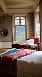 een slaapkamer met twee bedden en een raam bij Chateau de Gudanes in Château-Verdun