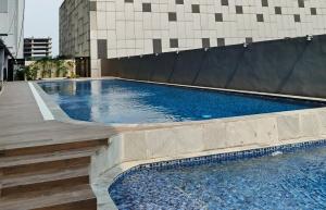 a swimming pool next to a building at Saffron Noble Apartment in Citaringgul 1
