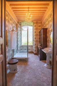 een badkamer met een bad, een toilet en een wastafel bij Chateau de Gudanes in Château-Verdun