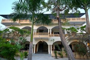 a building with palm trees in front of it at The Van Bagh Ranthambore in Sawāi Mādhopur